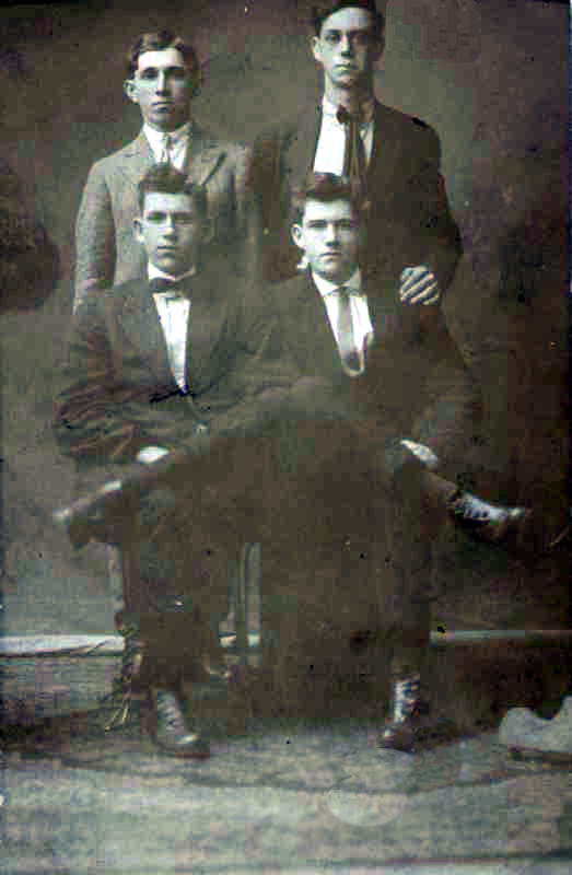 Four men, two seated and two standing